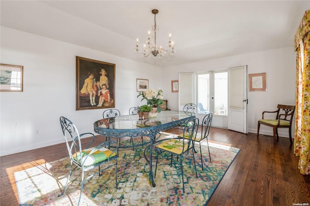 dining space with dark hardwood / wood-style flooring, french doors, and a notable chandelier