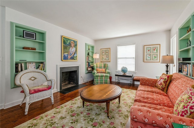 living room with dark hardwood / wood-style floors and built in shelves