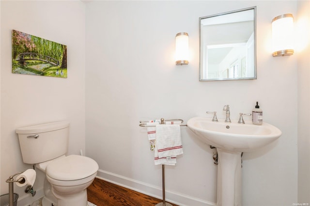 bathroom with wood-type flooring, toilet, and sink