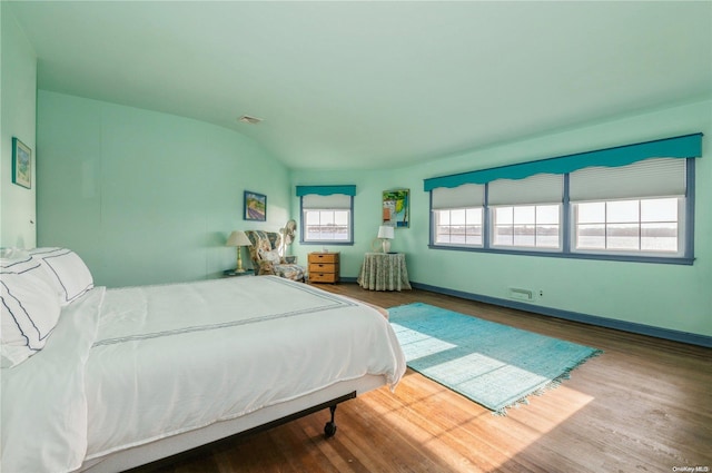 bedroom featuring wood-type flooring and vaulted ceiling