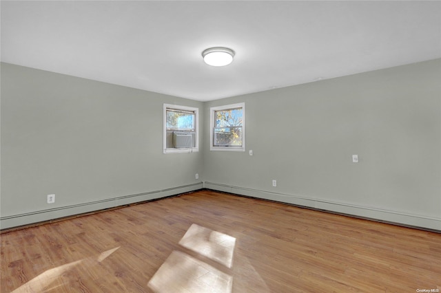 empty room with a baseboard radiator, light hardwood / wood-style flooring, and cooling unit