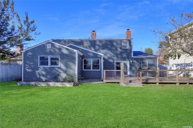 back of house with a deck and a lawn