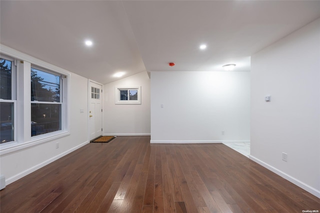 spare room featuring lofted ceiling and dark wood-type flooring