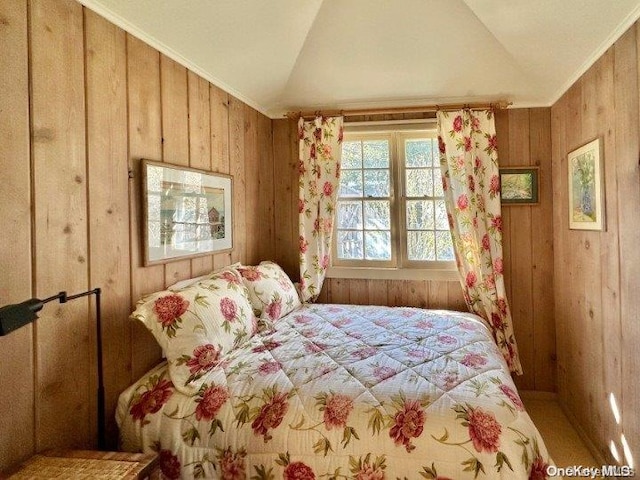 bedroom with wood walls, lofted ceiling, and ornamental molding