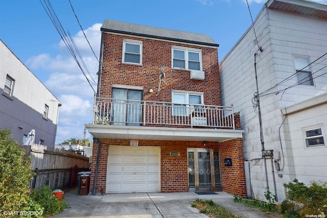 rear view of house with a garage and a balcony