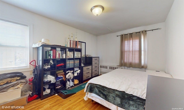 bedroom with hardwood / wood-style floors and radiator