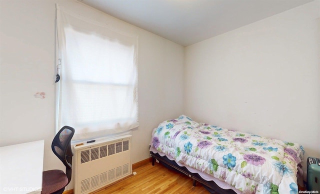 bedroom featuring light hardwood / wood-style floors and radiator