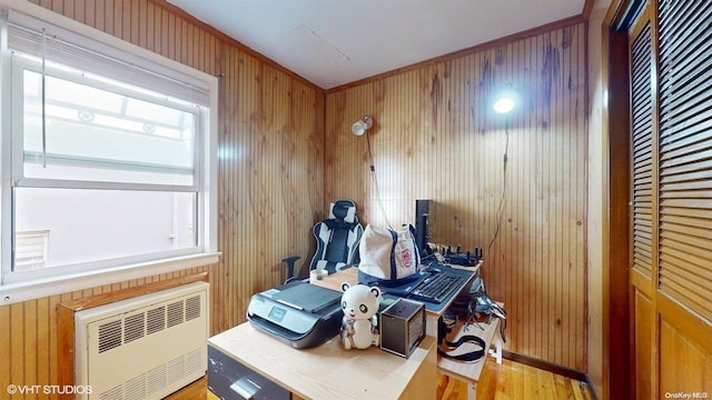 interior space with wood-type flooring, radiator, and wood walls