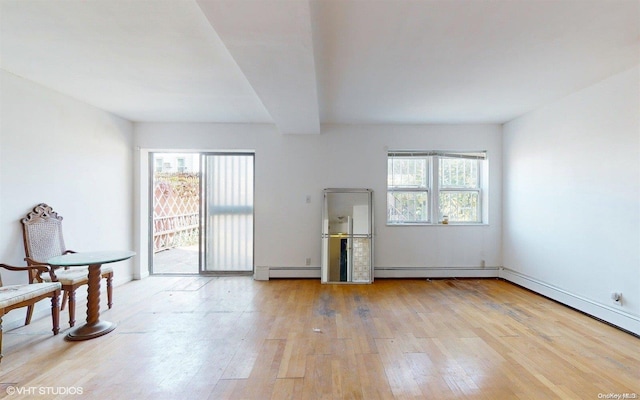 spare room featuring plenty of natural light, light hardwood / wood-style floors, and a baseboard heating unit