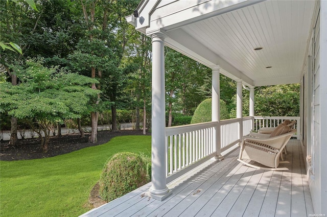 wooden deck with covered porch and a yard