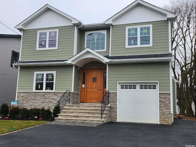 craftsman inspired home with stone siding, an attached garage, and driveway