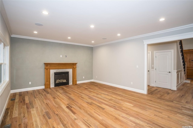 unfurnished living room with light wood-type flooring and crown molding