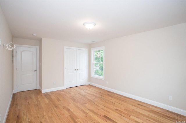 unfurnished bedroom featuring light wood-type flooring and a closet