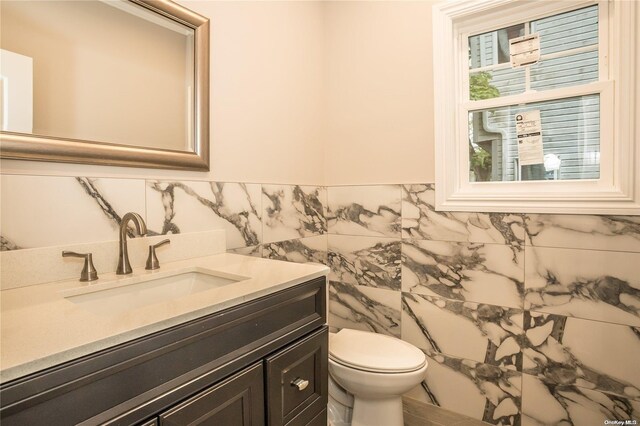 604 Meadowbrook Rd, North Merrick, NY 11566 - half bathroom with vanity, toilet, and tile walls