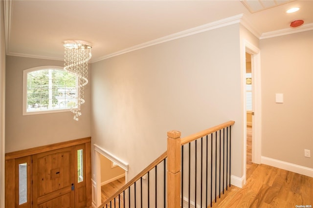 foyer with a notable chandelier, light hardwood / wood-style floors, and ornamental molding