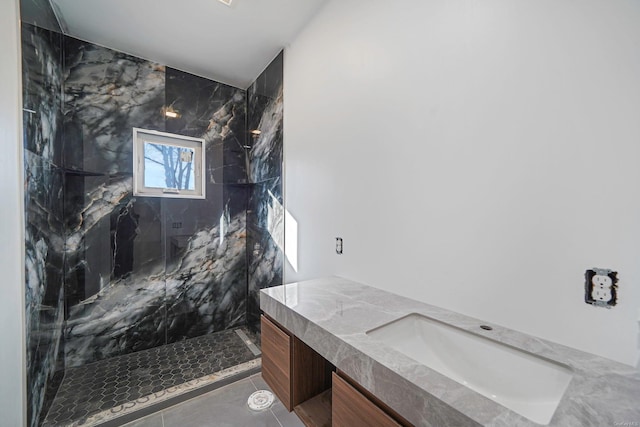 full bathroom with a marble finish shower, vanity, and tile patterned floors