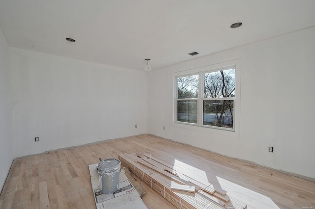 unfurnished room with visible vents and wood finished floors