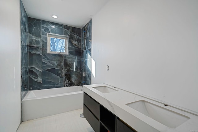 full bath with double vanity, tile patterned flooring, a sink, and shower / tub combination