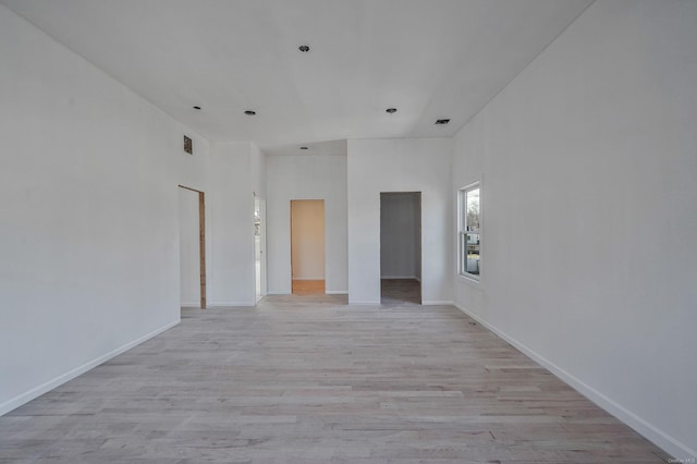 unfurnished room with light wood-style flooring, visible vents, and baseboards