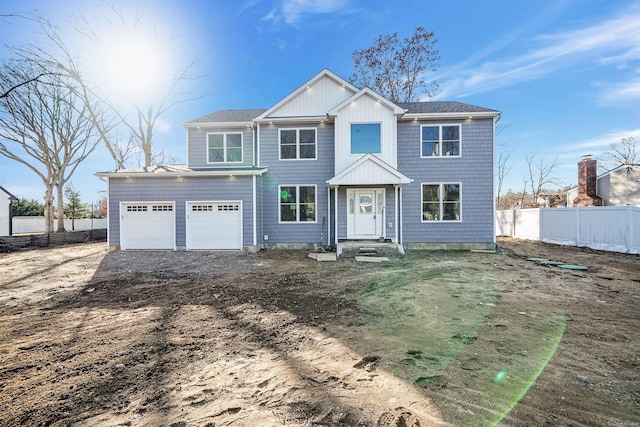 view of front of home featuring driveway, an attached garage, and fence