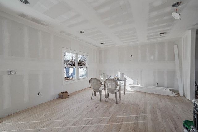 unfurnished dining area featuring light wood-type flooring and coffered ceiling