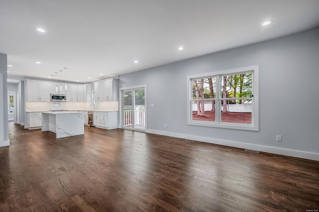 146 Walter Ave, Hauppauge, NY 11788 - unfurnished living room featuring baseboards, dark wood-type flooring, and recessed lighting