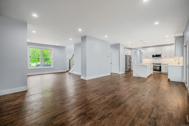 146 Walter Ave, Hauppauge, NY 11788 - unfurnished living room with recessed lighting, dark wood finished floors, stairway, and a sink
