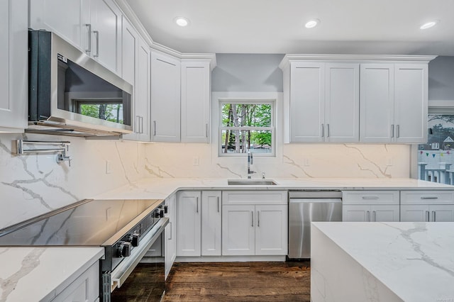 146 Walter Ave, Hauppauge, NY 11788 - kitchen featuring dark wood finished floors, a sink, decorative backsplash, white cabinets, and appliances with stainless steel finishes