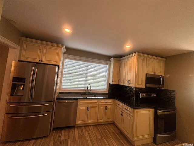 kitchen with hardwood / wood-style flooring, sink, stainless steel appliances, and tasteful backsplash