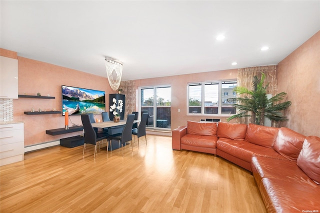 living room featuring an inviting chandelier, a baseboard radiator, and light wood-type flooring