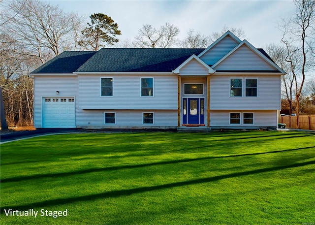 raised ranch featuring a garage and a front yard