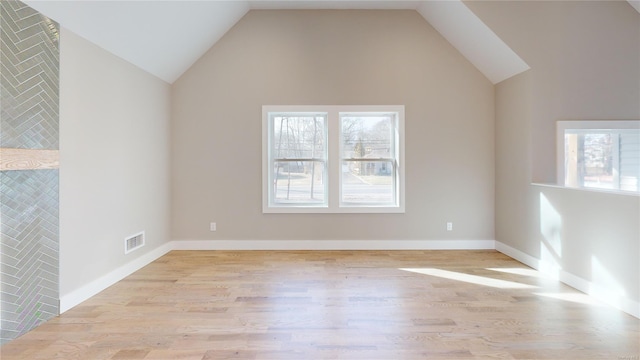 empty room with lofted ceiling and light hardwood / wood-style flooring