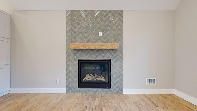 interior details featuring hardwood / wood-style floors and a tile fireplace