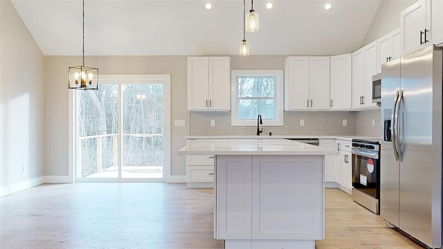 kitchen featuring white cabinetry, a center island, stainless steel appliances, and pendant lighting