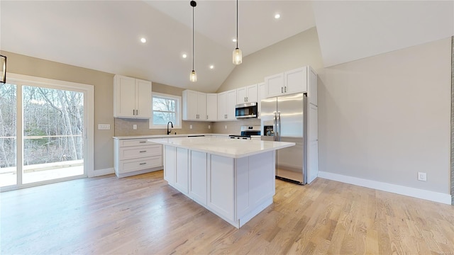 kitchen featuring backsplash, a kitchen island, stainless steel appliances, high vaulted ceiling, and white cabinets