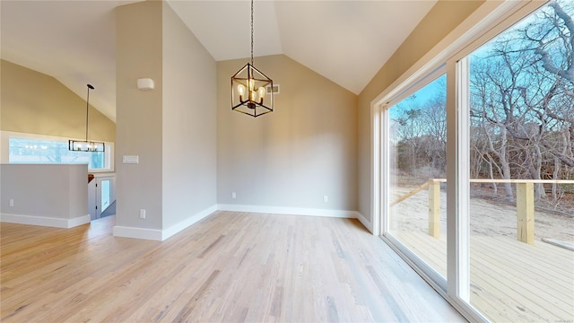 unfurnished dining area with light hardwood / wood-style floors, an inviting chandelier, and vaulted ceiling