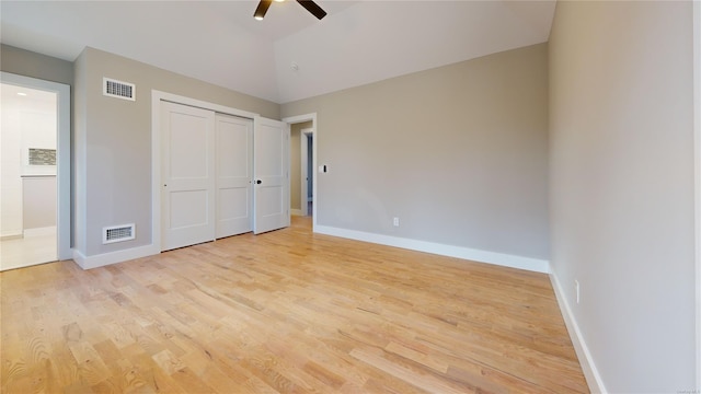 unfurnished bedroom featuring ceiling fan, lofted ceiling, light hardwood / wood-style floors, and a closet