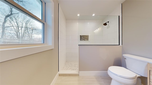 bathroom featuring toilet and tiled shower