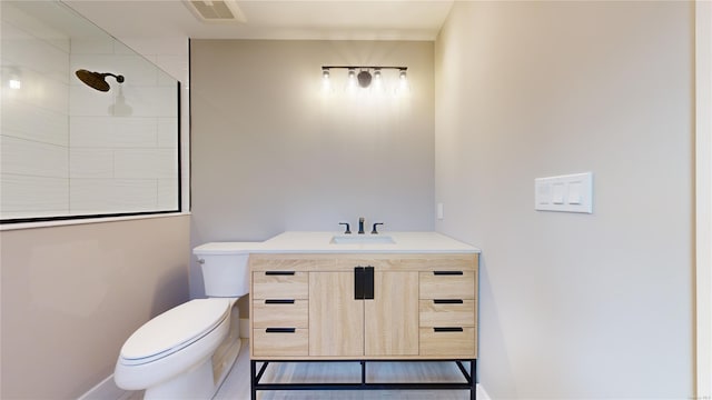 bathroom featuring toilet, vanity, and walk in shower