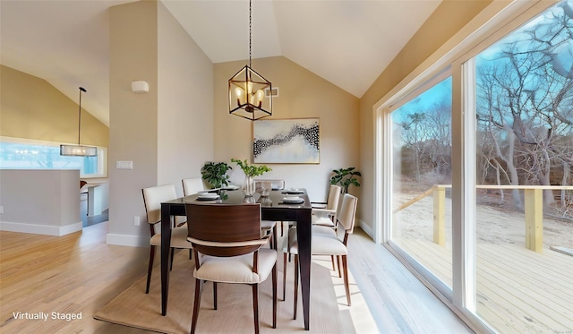 dining room featuring an inviting chandelier, lofted ceiling, light hardwood / wood-style flooring, and a wealth of natural light