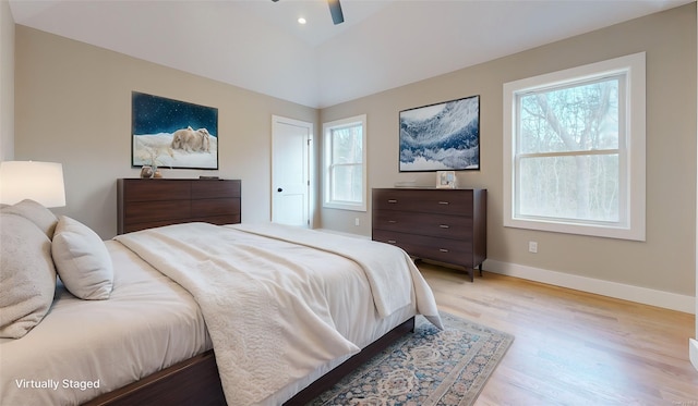 bedroom featuring ceiling fan, multiple windows, and light hardwood / wood-style flooring