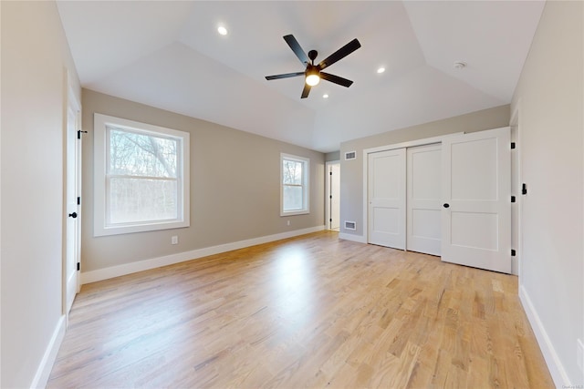 unfurnished bedroom with lofted ceiling, light hardwood / wood-style floors, a closet, and ceiling fan