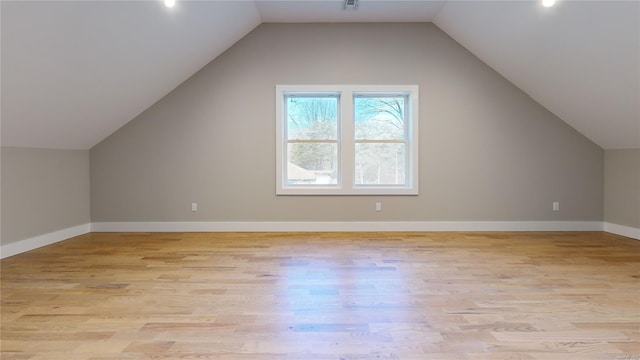 additional living space with vaulted ceiling and light hardwood / wood-style floors