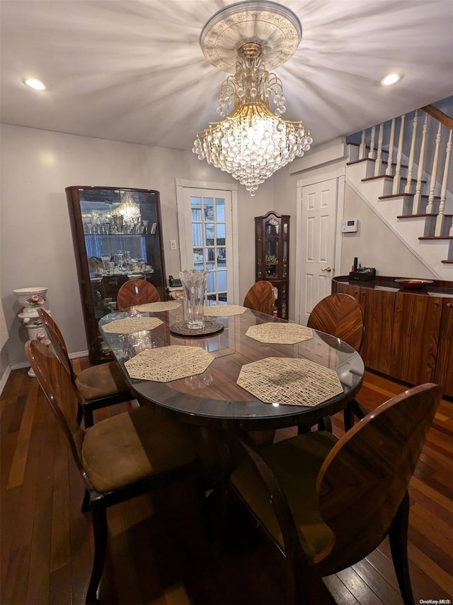 dining room with dark wood-type flooring and a chandelier