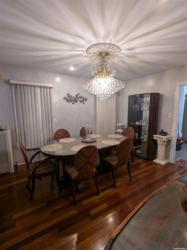 dining space featuring radiator heating unit, dark hardwood / wood-style flooring, and an inviting chandelier