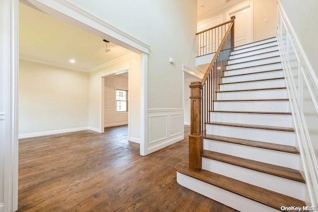 staircase featuring hardwood / wood-style floors and crown molding