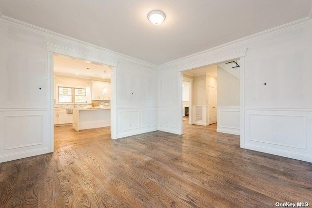 spare room with hardwood / wood-style floors and crown molding