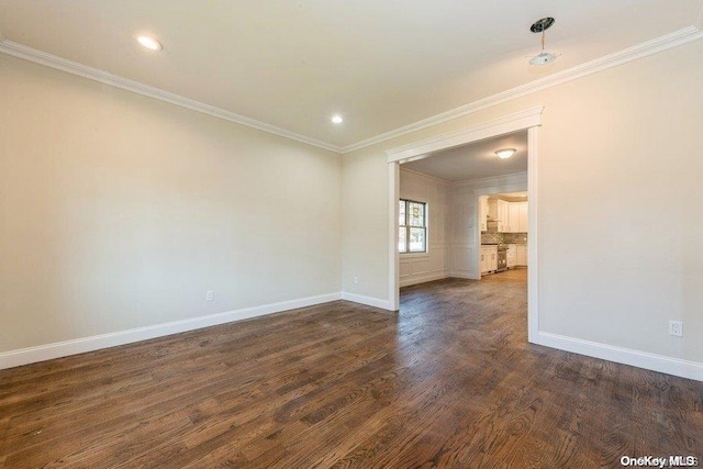 unfurnished room featuring dark wood-type flooring and ornamental molding