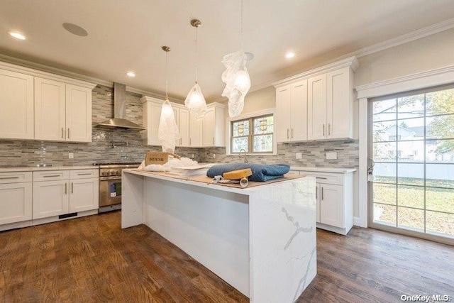 kitchen featuring plenty of natural light, white cabinetry, wall chimney range hood, and high end range