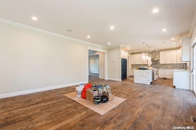 kitchen with a center island, white cabinets, hanging light fixtures, ornamental molding, and wood-type flooring